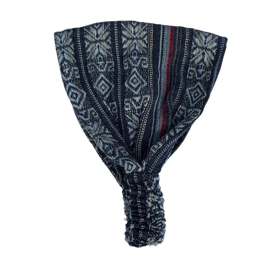 A dust gray beige wide headband with geometric patterns and blue, red, and black stripes, designed for adults.
