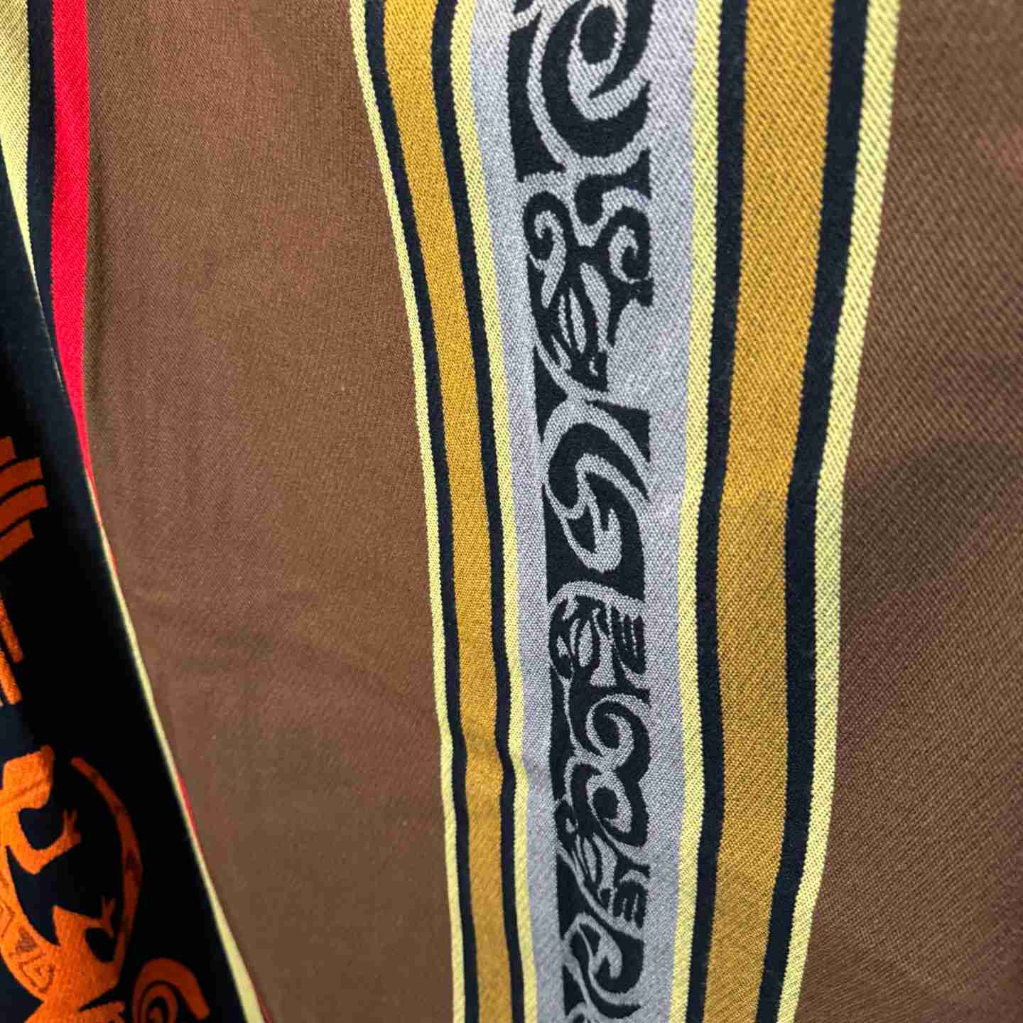 Close-up of sun symbol and four-directions pattern on Four Directions Earth poncho