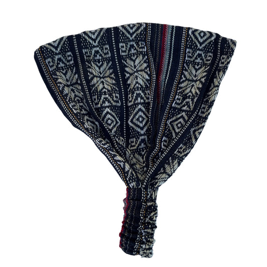 A wide headband featuring a geometric pattern in black, tan, and red colors.